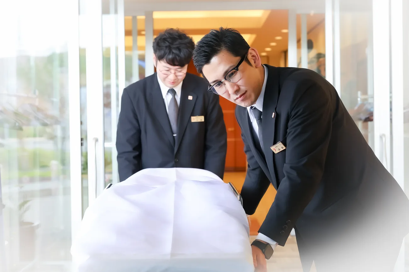 棺を丁寧に運ぶ男性スタッフ